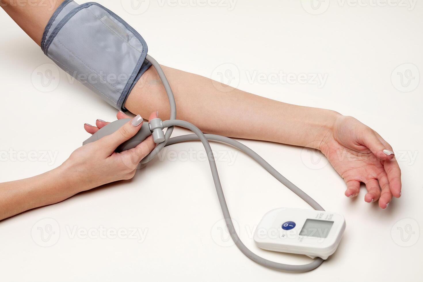 sangre presión medición. mujer manos con tonómetro en blanco antecedentes. foto