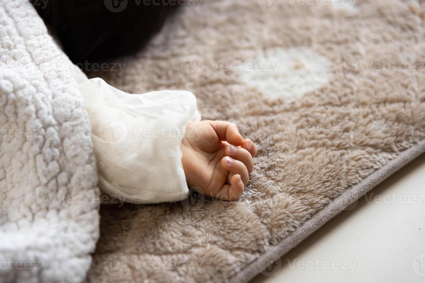 A left hand of sleeping asian baby on the carpet photo