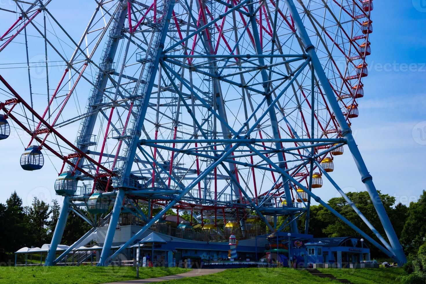 A ferris wheel at the park behind the blue sky telephoto shot photo