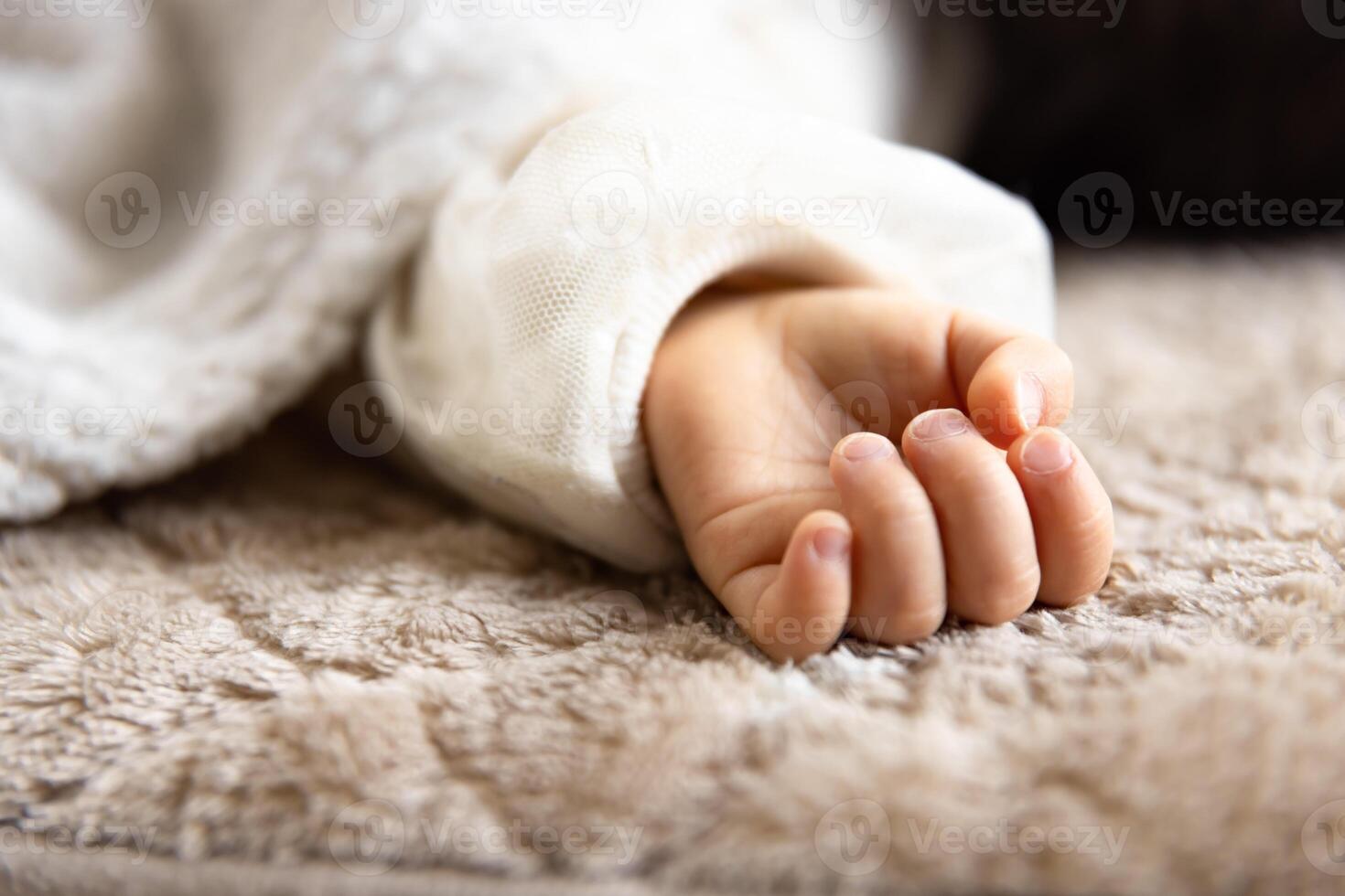 A left hand of sleeping asian baby on the carpet photo