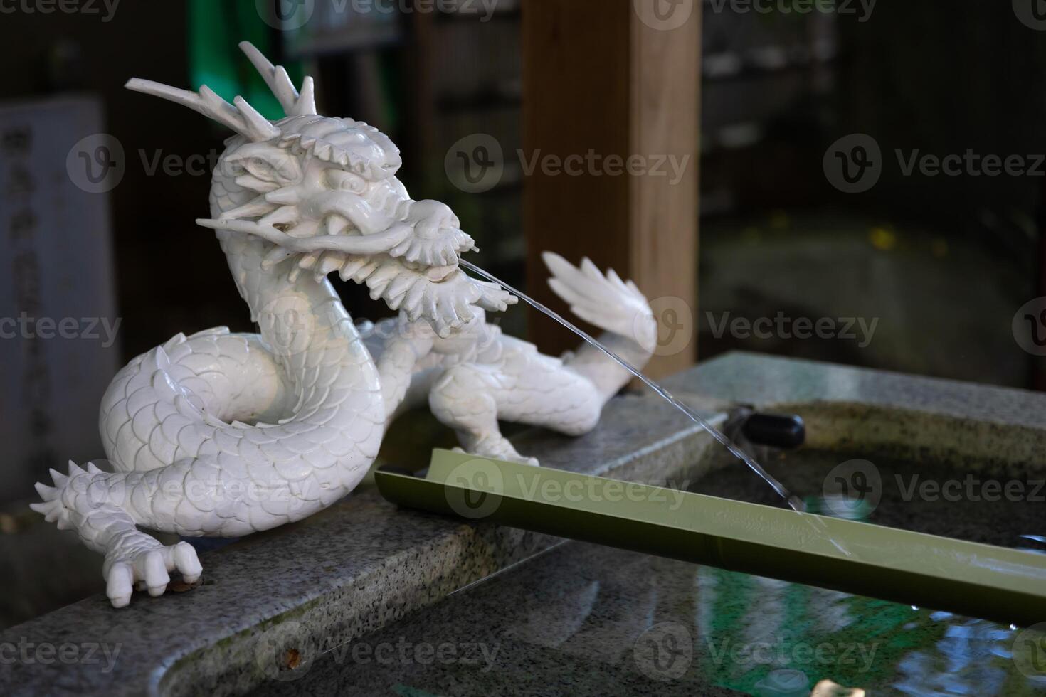 A statue of dragon at purification fountain in Japanese Shrine photo