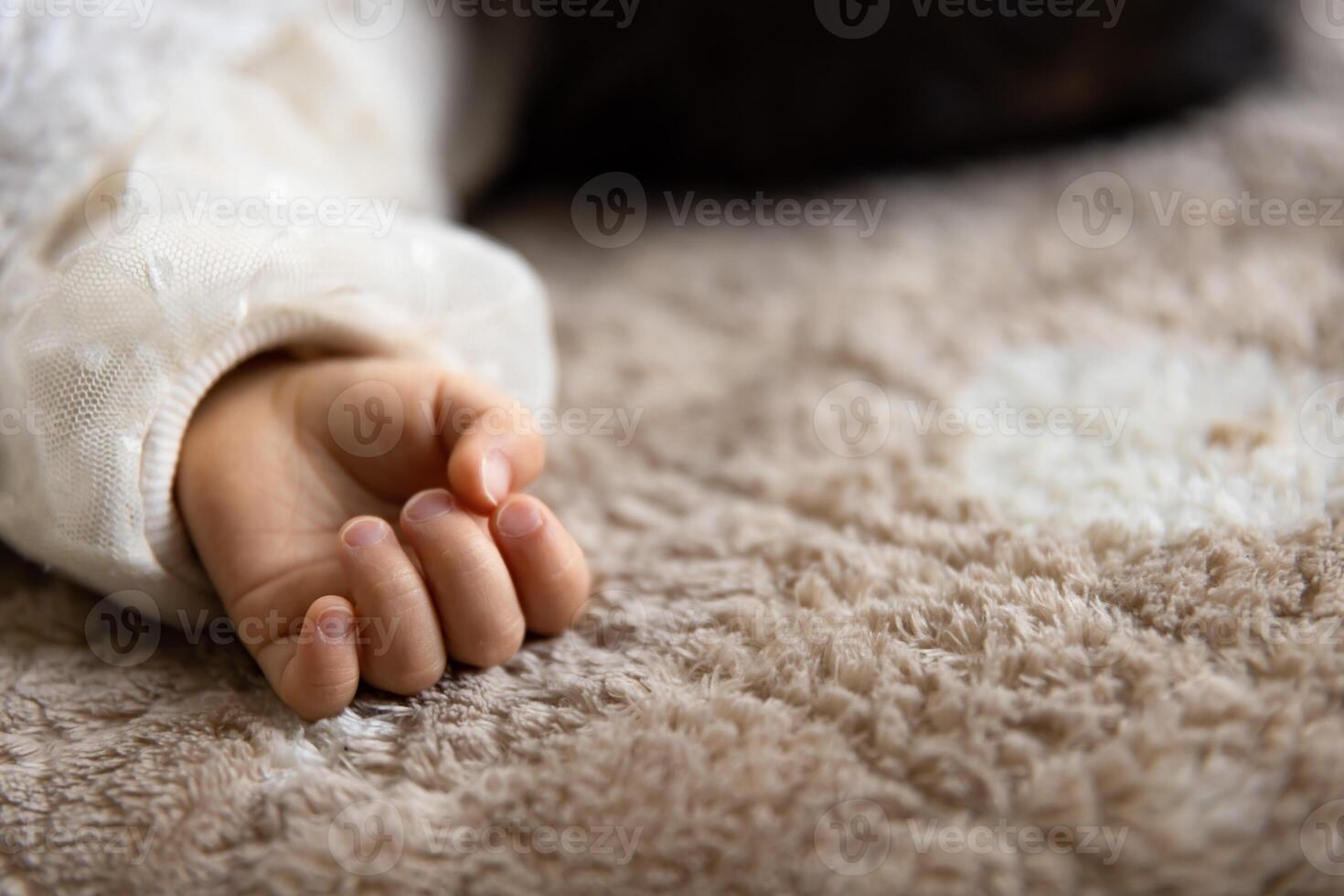 un izquierda mano de dormido asiático bebé en el alfombra foto