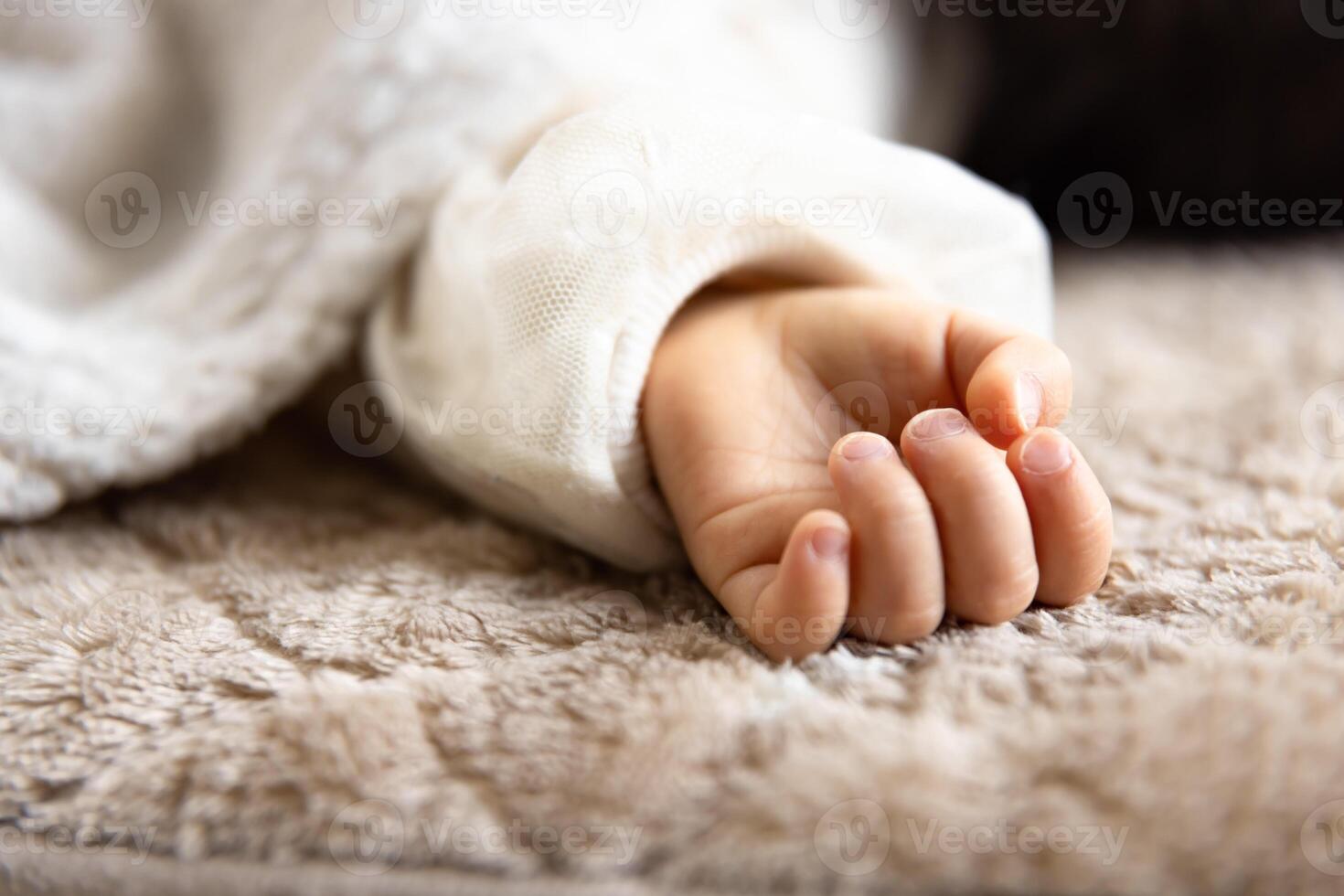 A left hand of sleeping asian baby on the carpet photo