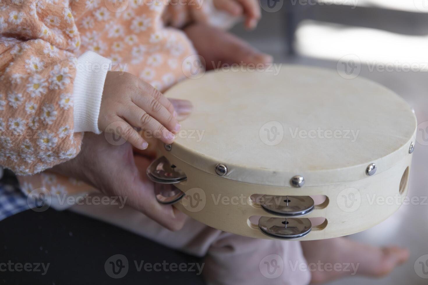 Child's hands with tambourine in the living room closeup photo