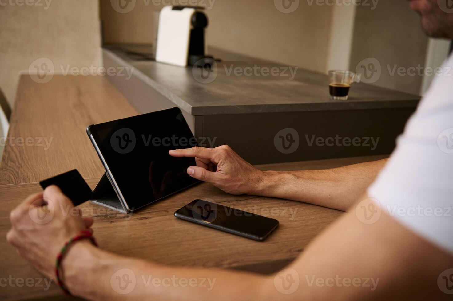 Close-up man holds credit card, using digital tablet with blank mockup touch screen. Copy advertising space for text photo