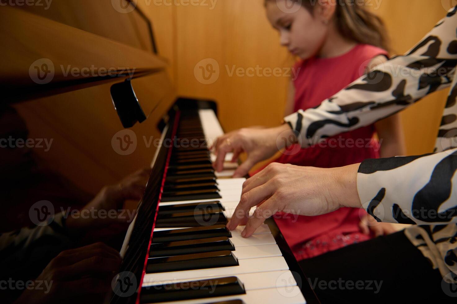 Close-up hands of a woman, pianist teacher giving piano lesson, passionately playing the keys, creating melody, feeling the rhythm of music. Musical education and talent development in progress photo