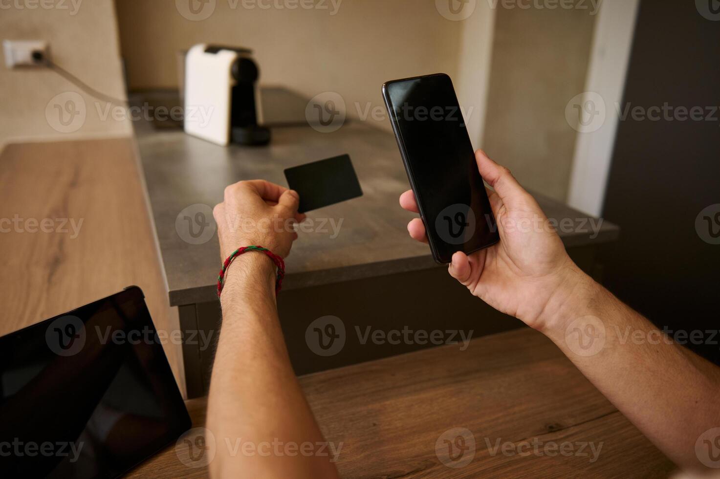 Male hands hold credit card and smartphone, transferring money via internet banking, making payment, using mobile app photo