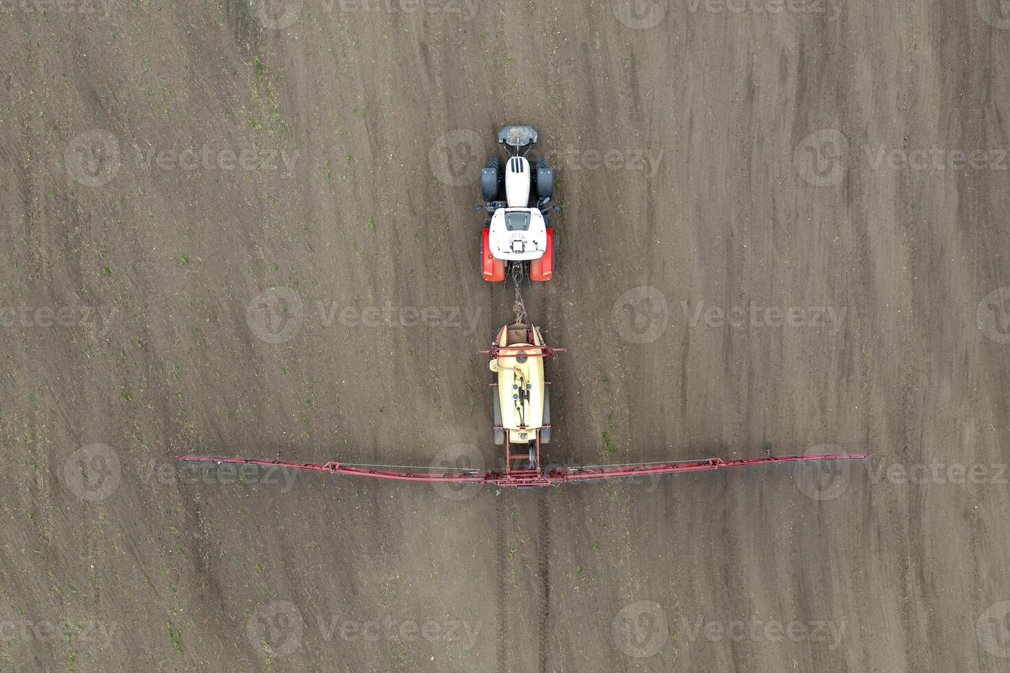 Top view of tractor spraying grain on a field. photo