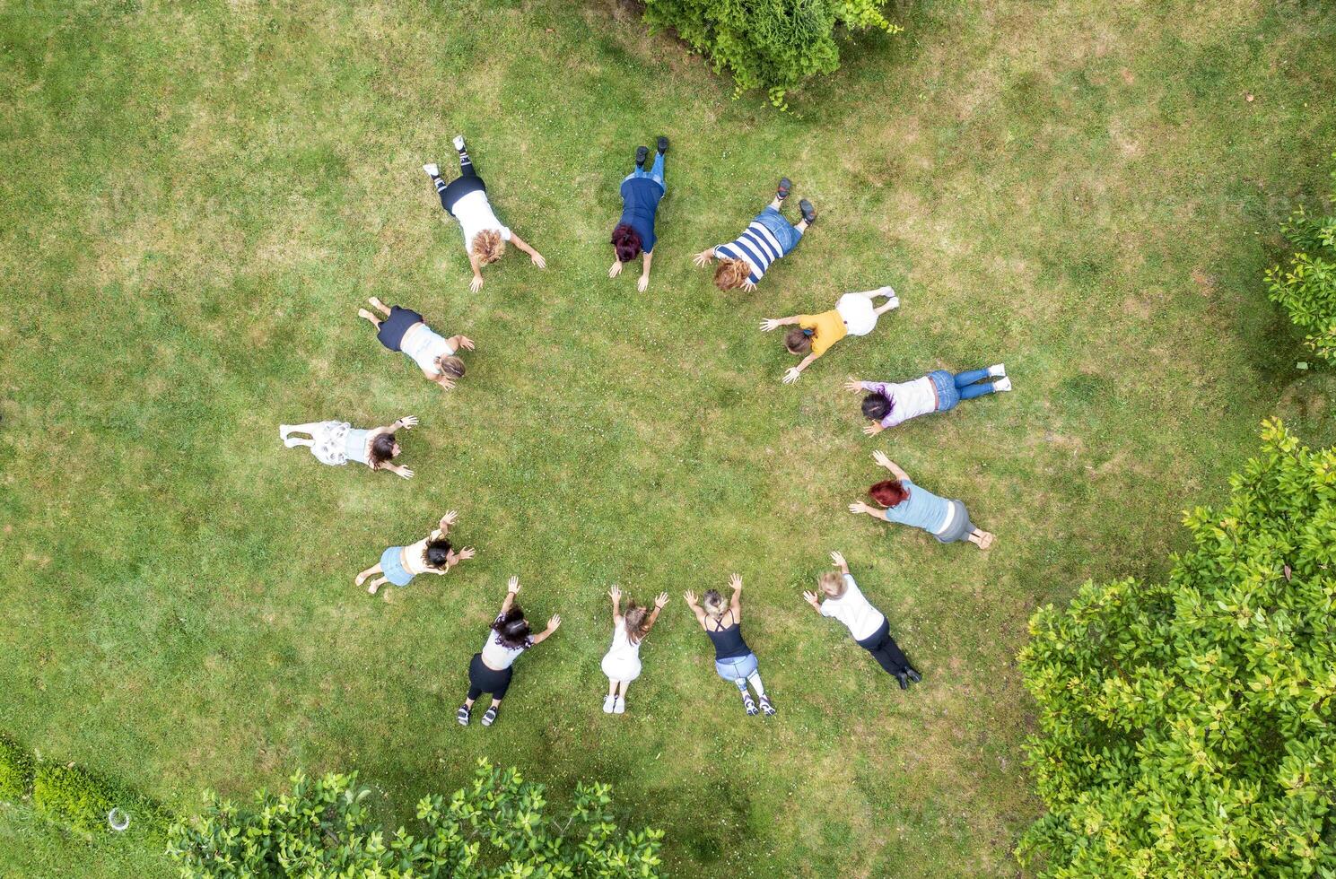 Top aerial view of people standing in circle on green grass. photo