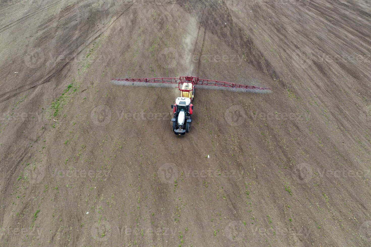 Top view of tractor spraying grain on a field. photo