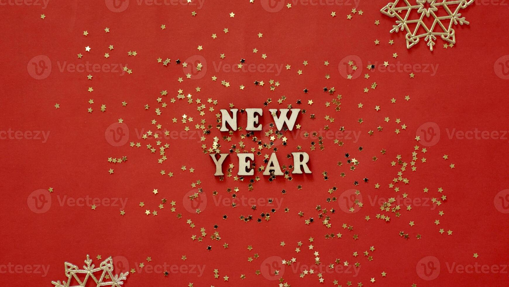 Christmas flatley with New Year lettering on red gold background baubles decoration. Close-up, shiny composition. Postcard photo