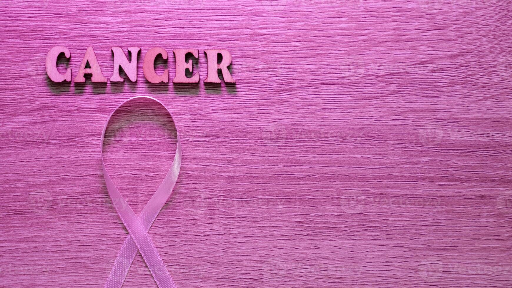 Wooden Pink Neon Background image Breast cancer Awareness is celebrated in October Month. The inscription with the symbol is a ribbon. Close-up, copy space , past text photo