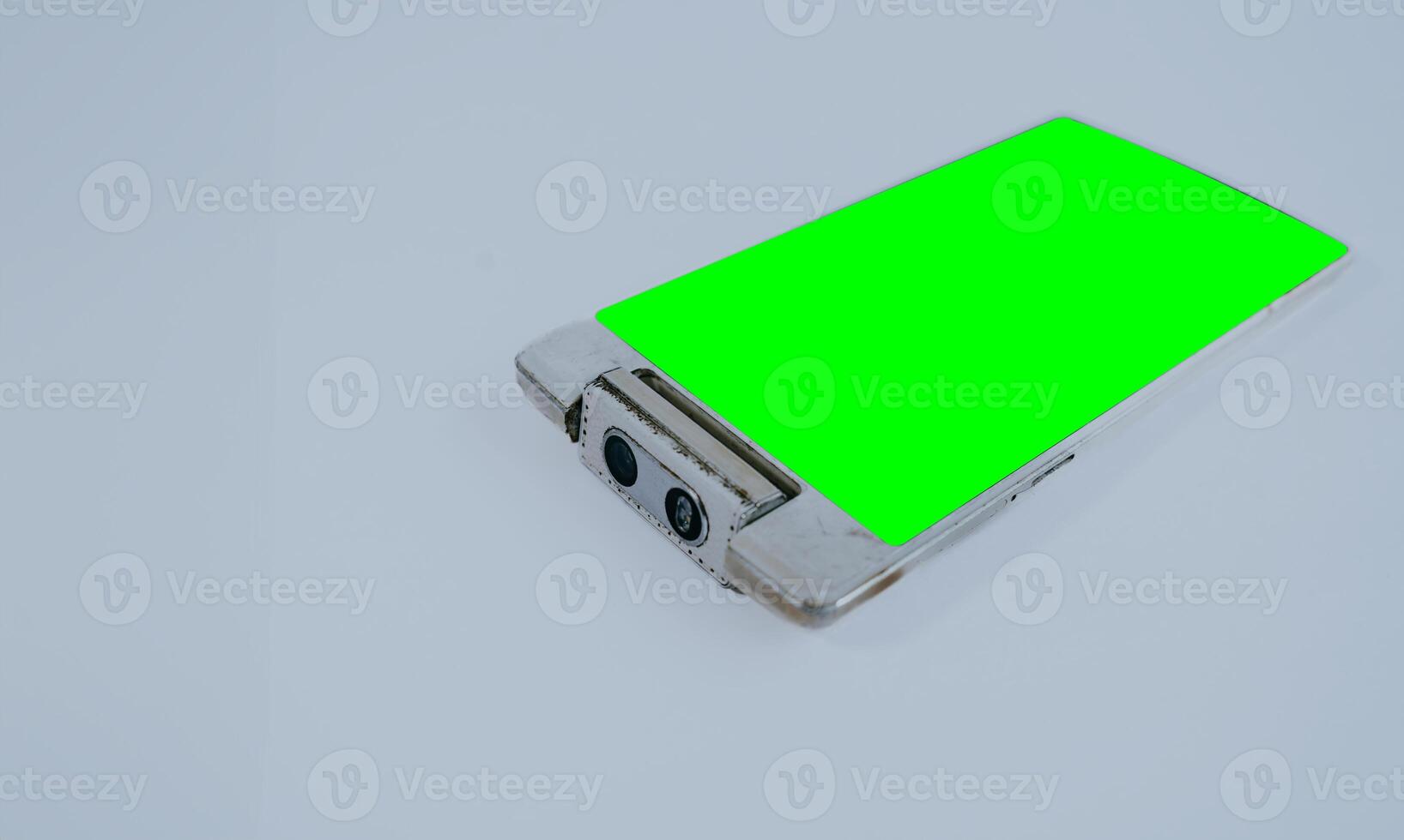 Mockup smart phone old generation with rotate camera and green screen, copy space isolated on white. photo