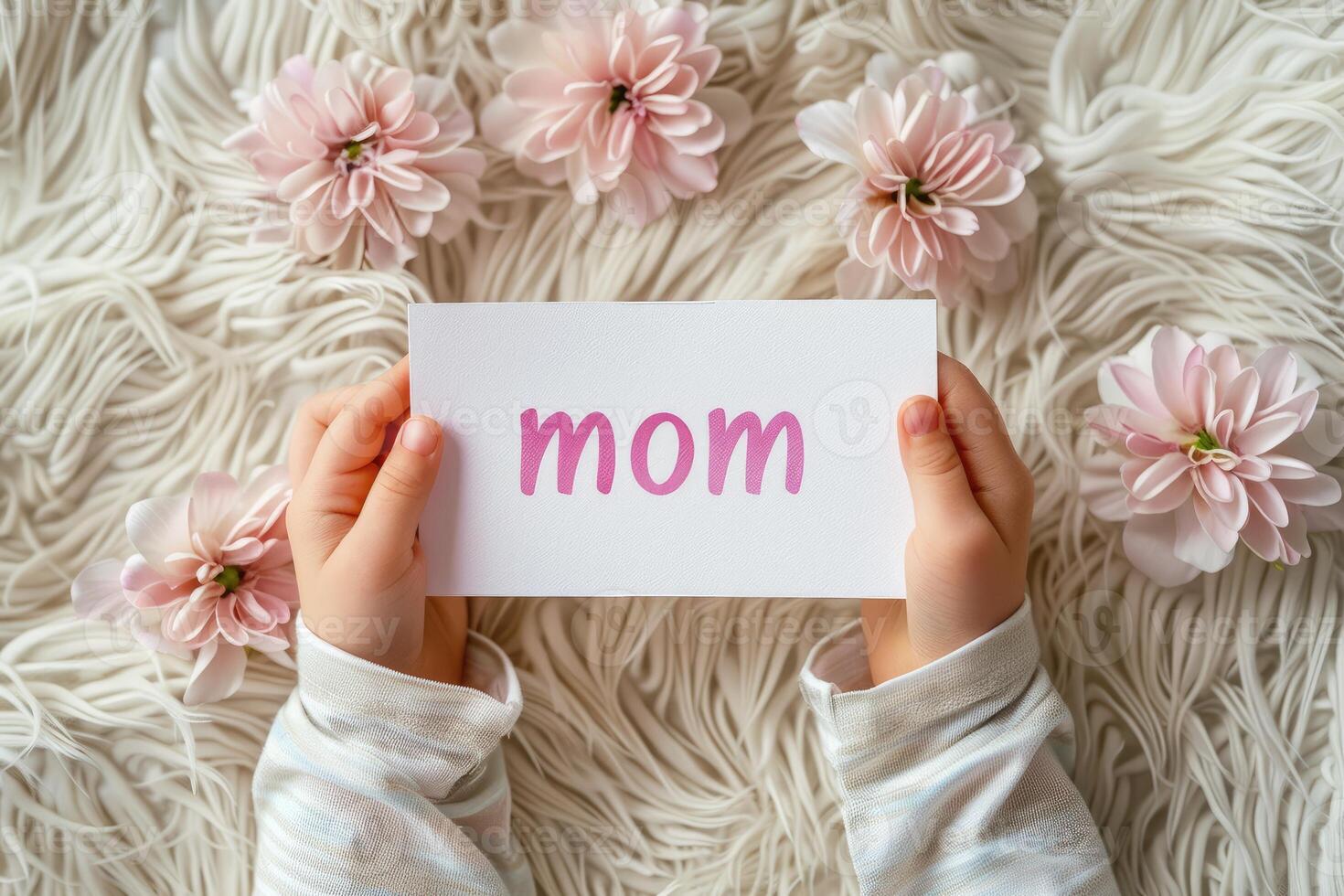 AI generated Happy Mother's Day or International Day of Families. Top view of children's hands holding card with text Mom on background of pink flowers photo