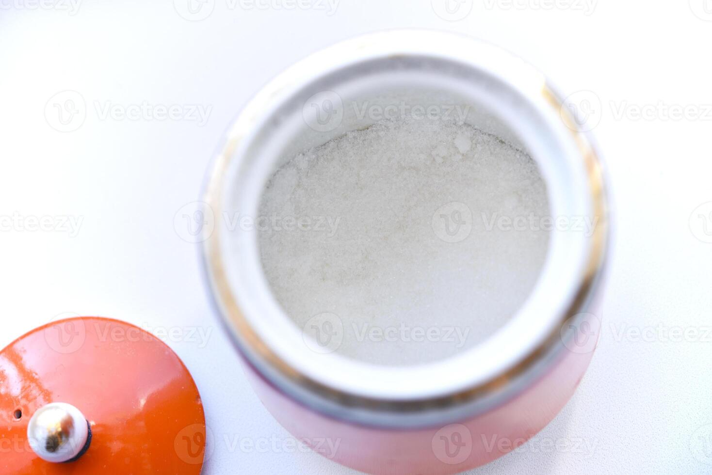 Red ceramic sugar bowl on a white background. Sugar in a jar. photo