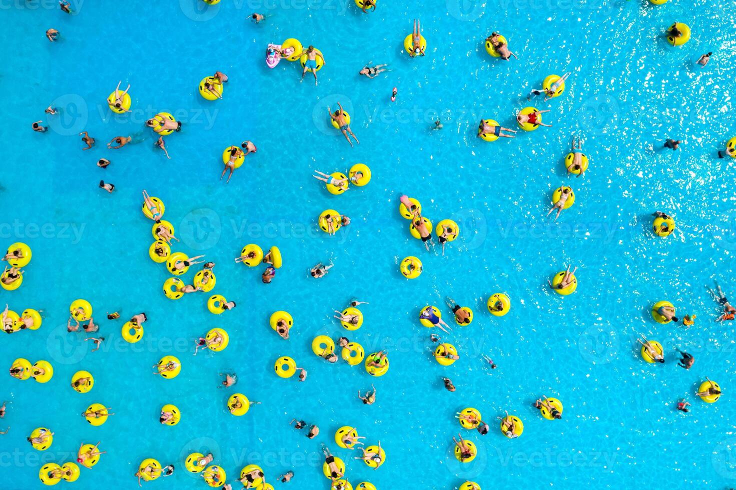 Top view of People relaxing in the pool on yellow inflatable circles photo