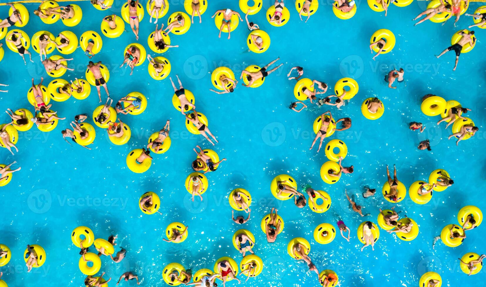 Top view of People relaxing in the pool on yellow inflatable circles photo