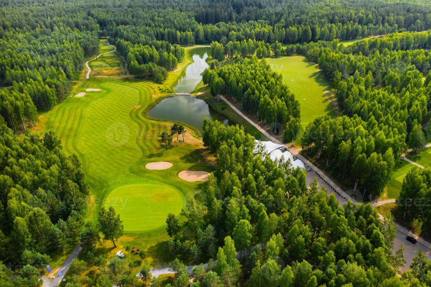 Top view of the golf course located in a wooded area photo