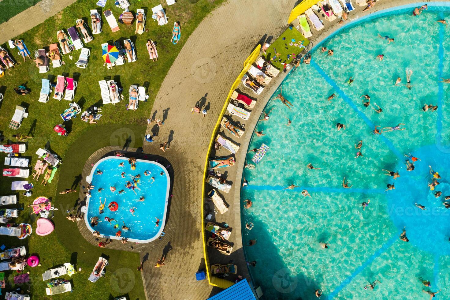 Top view of an outdoor place for people to relax where there is a swimming pool and a lot of sun beds photo