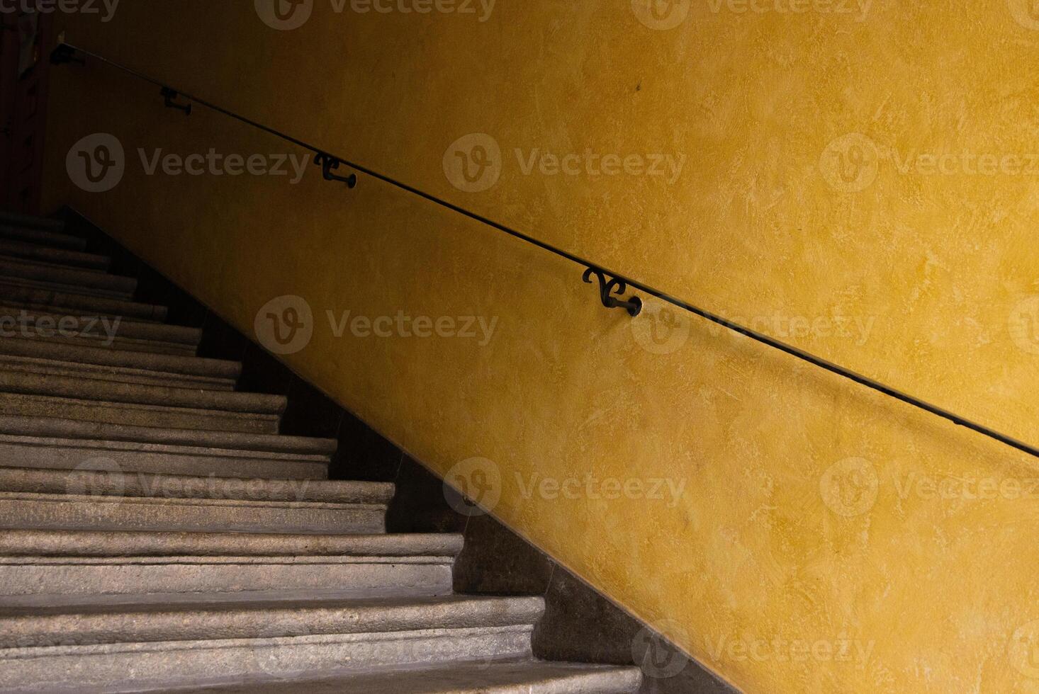 Yellow wall with stairs and metal railing. Vintage background. Minimalistic Conceptual design and simplicity. Base image for posters, banners or covers. Graphic arts photo