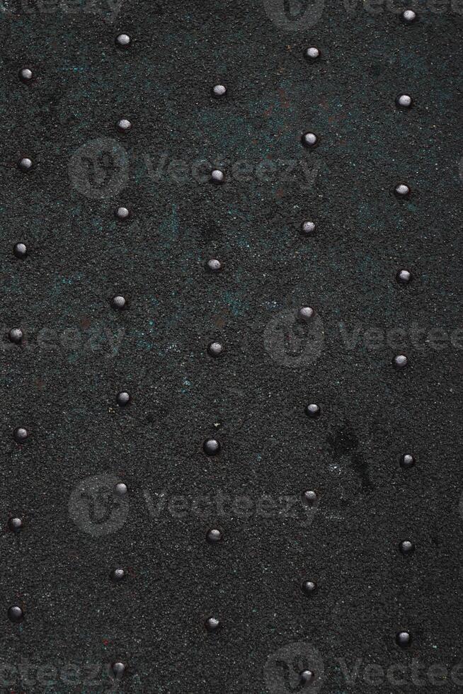 Grunge steel industrial boat floor plate painted dark gray black anti-rust paint. Robust ferry ship metal pattern. Old dotted iron deck. Worn metal texture background. Modern art concept. Copy space photo