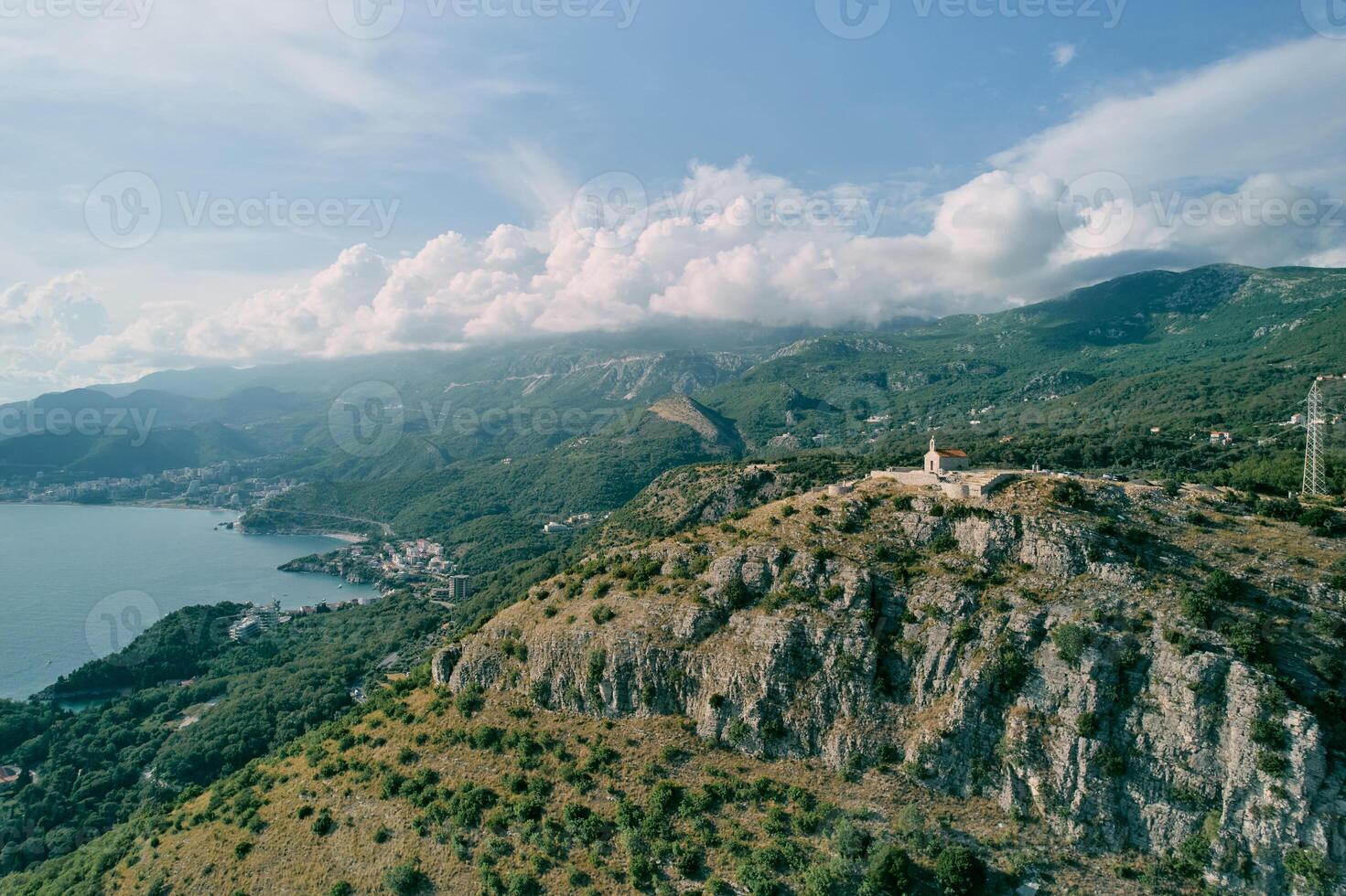 Church of St. Sava on a rocky mountain overlooking the green mountain range above the Bay of Kotor. Montenegro. Drone photo