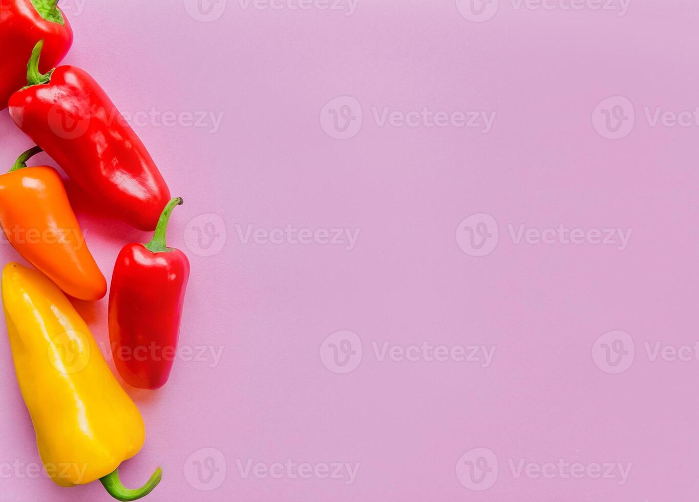 Colorful Bell Peppers on Pink Background for Healthy Food Concept photo