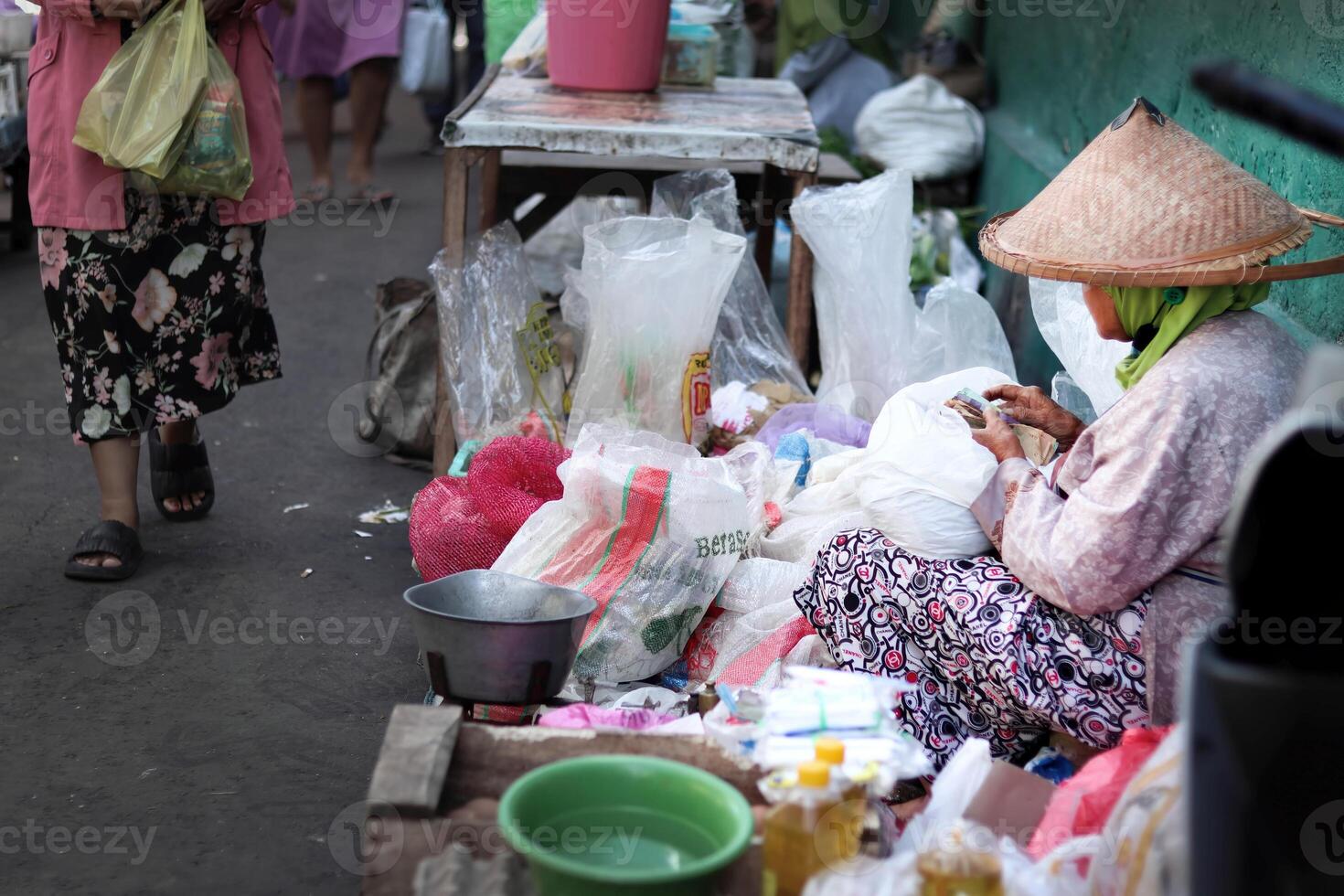 a trader at a traditional market is counting the money from his sales photo