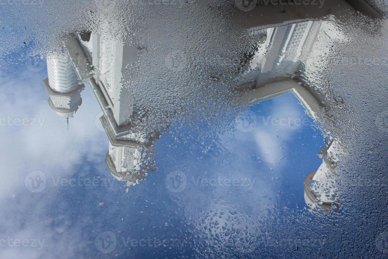 View of the White Mosque with water reflections on the road against a blue sky background photo