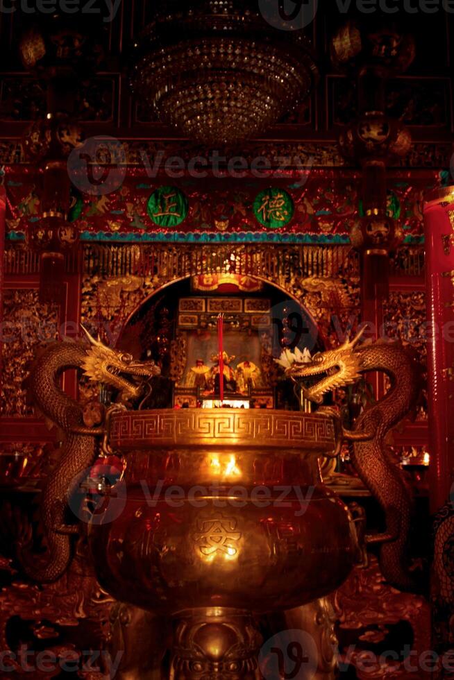 Burning prayer sticks fill the room with billowing smoke with dragon decorations on the sides at the Chinese New Year celebration. Eng An Kiong Temple, Malang, Indonesia photo