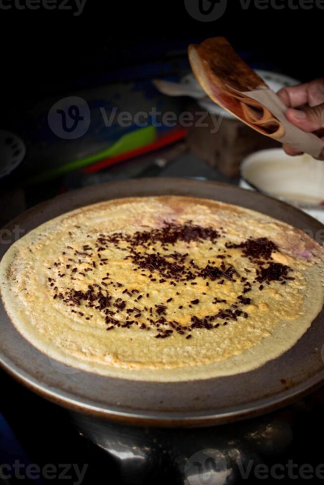 image of sweet crepes covered in sprinkles and chocolate taken at an angle photo