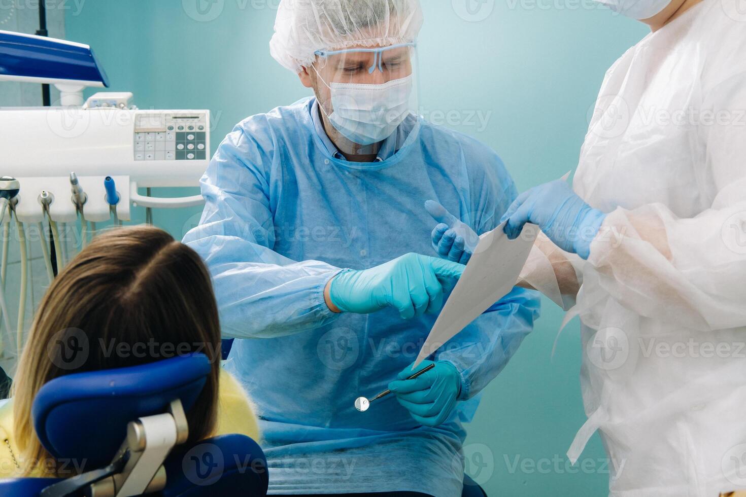 Dentist explaining the details of the X-ray to his patient in the office photo