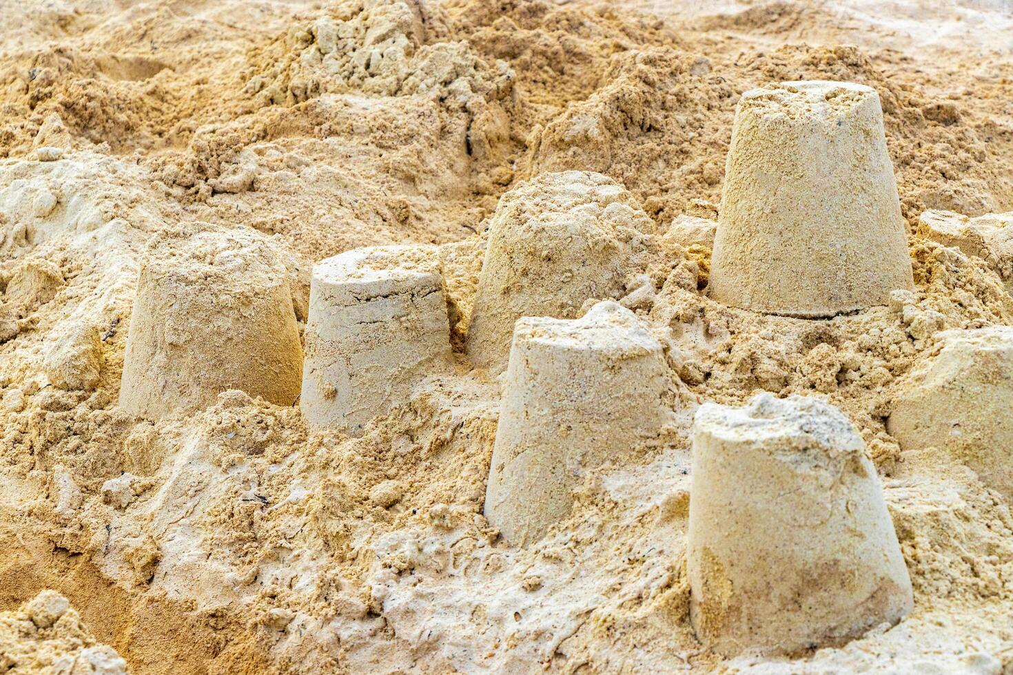 Castle made of white sand with buckets on beach Mexico. photo