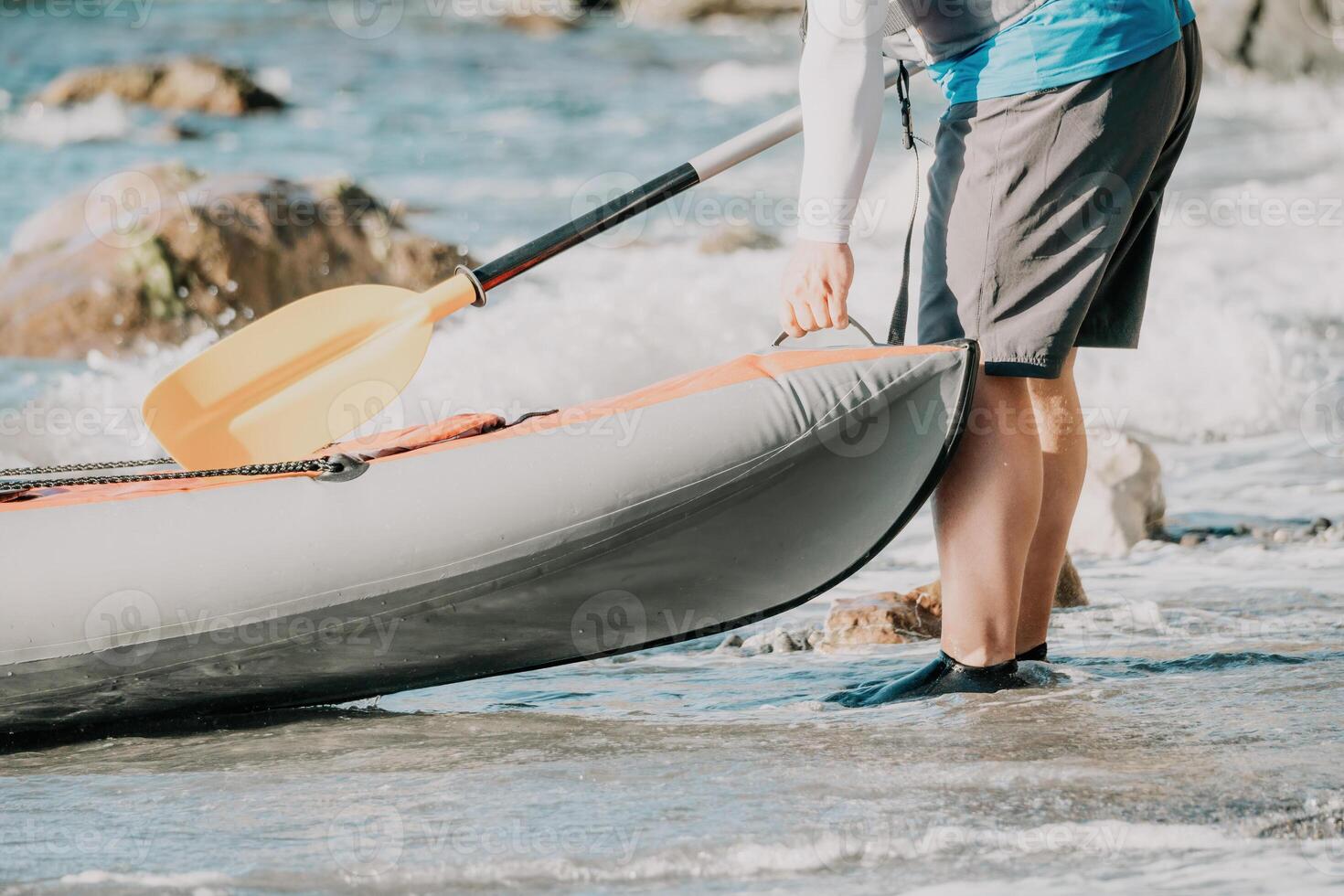 Happy couple kayaks in an inflatable kayak on the sea at sunset. Couple kanoeing in the sea near the island with mountains. People kayaking in life jackets sail. Back view photo