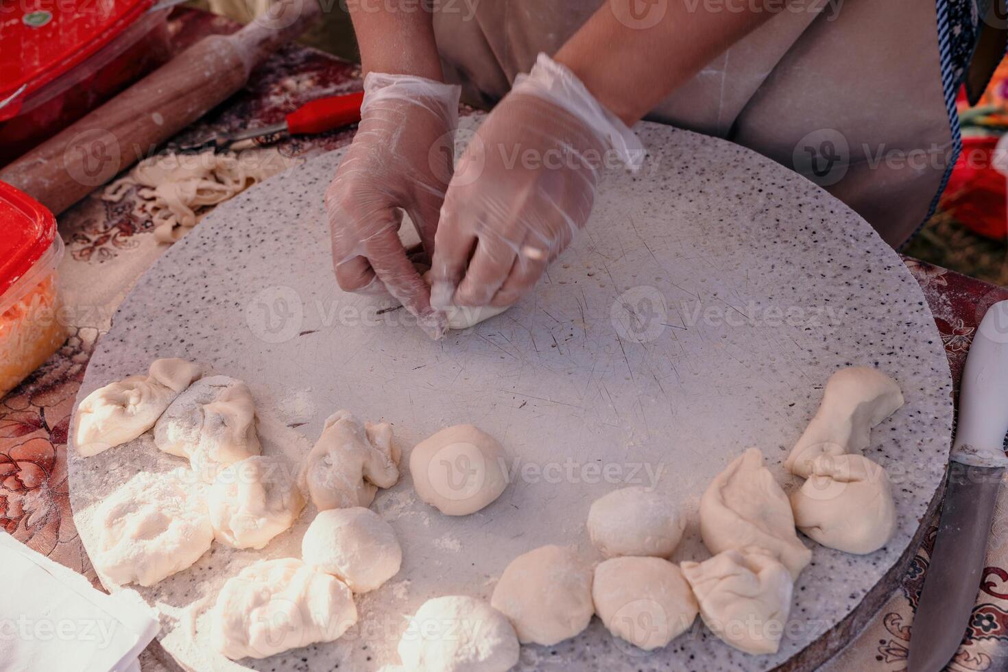 woman's hands making qutab or chebureki with a rolling pin and minced meat onion in dough for culinary concepts related to Azerbaijani, Tatar and Greek cuisine, as well as empanadas in Latin America. photo