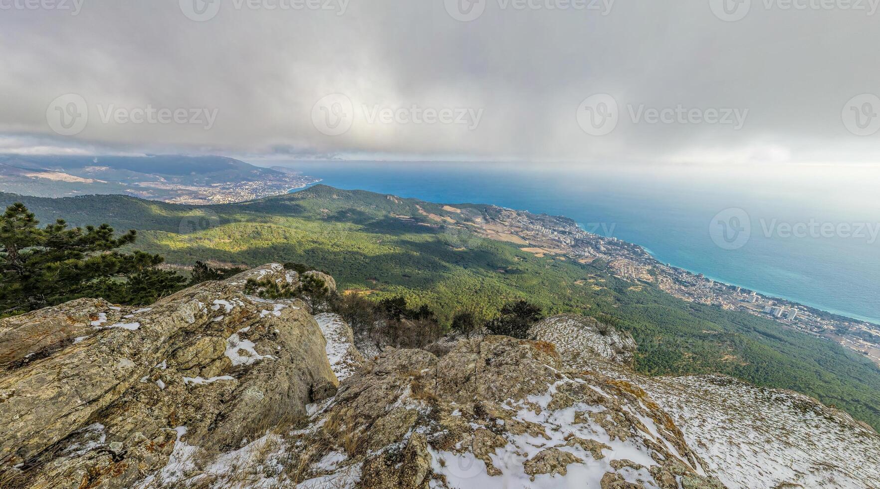 Winter snow mountain panorama. panoramic aerial view above sea and snow covered frozen mountains with deep blue sky and a beautiful radiant sun. Cold weather and climate change photo