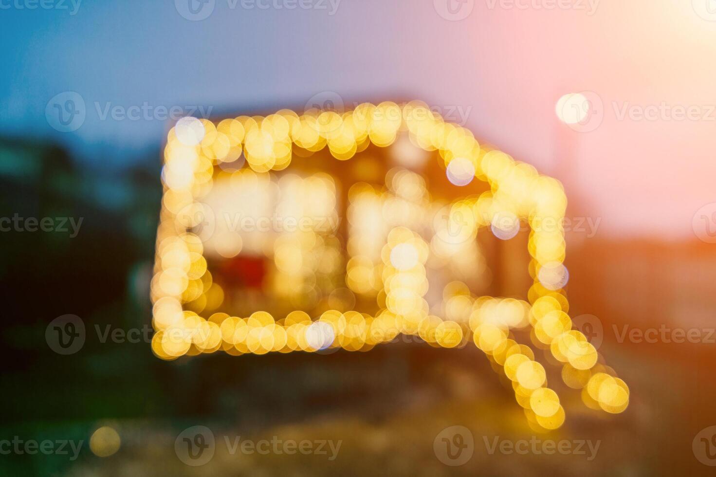 Abstract defocused bright Christmas lights on wooden house, creating decorative illumination in evening scene photo