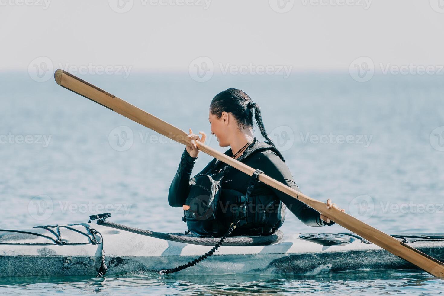 mujer mar kayac. contento sonriente mujer en kayac en océano, remar con de madera remo. calma mar agua y horizonte en antecedentes. activo estilo de vida a mar. verano vacaciones. foto