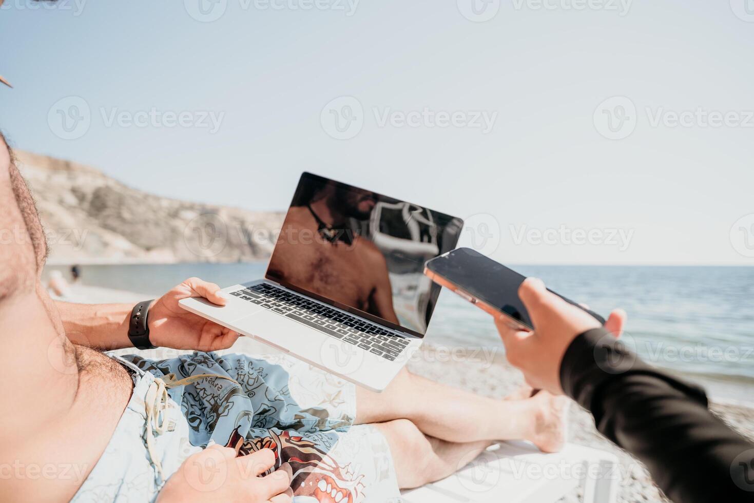 Man woman laptop sea. Working remotely on seashore. Happy successful couple, freelancers working on sea beach, relieves stress from work to restore life balance. Freelance, remote work on vacation photo