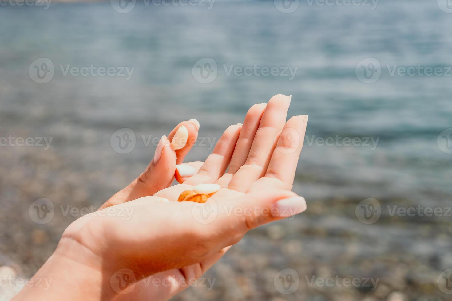 Woman eating milky almond nuts. A young caucasian woman chopping fresh green almond after morning fitness yoga near sea. Only hands are visibly. Healthy vegan food. Slow motion. Close up photo