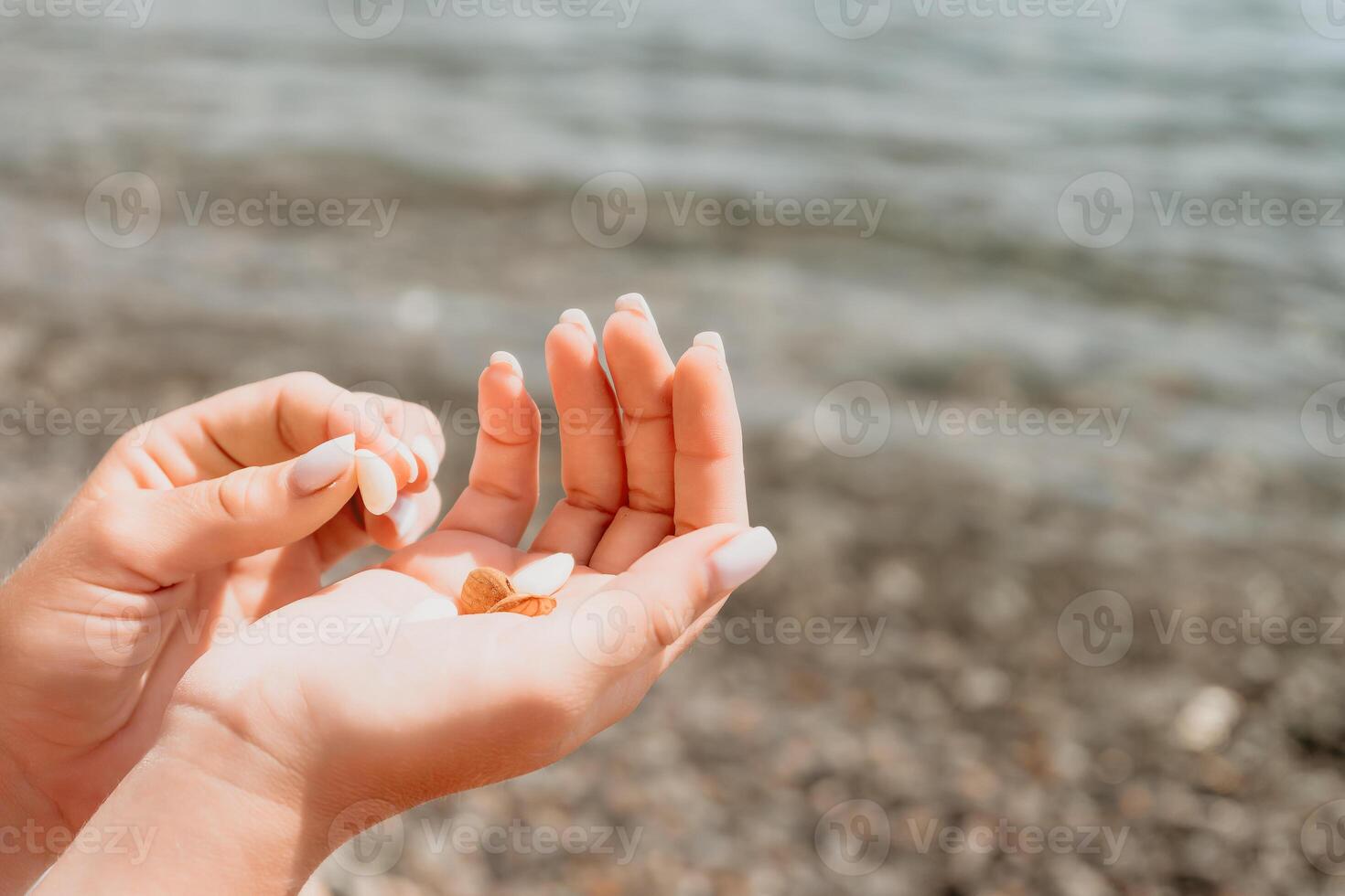 Woman eating milky almond nuts. A young caucasian woman chopping fresh green almond after morning fitness yoga near sea. Only hands are visibly. Healthy vegan food. Slow motion. Close up photo