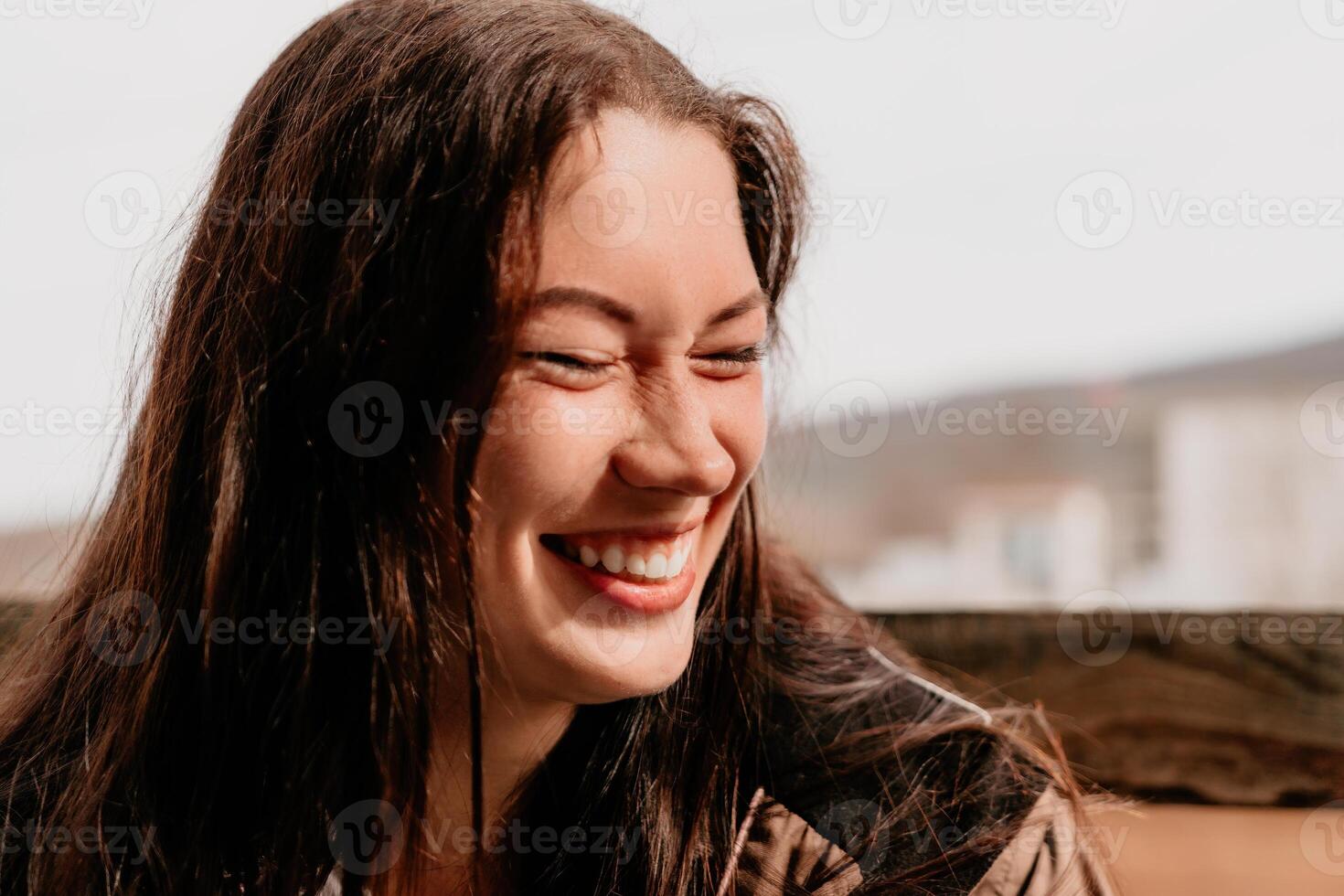 contento joven sonriente mujer con pecas al aire libre retrato. suave soleado colores. al aire libre de cerca retrato de un joven morena mujer y mirando a el cámara, posando en contra otoño naturaleza antecedentes foto