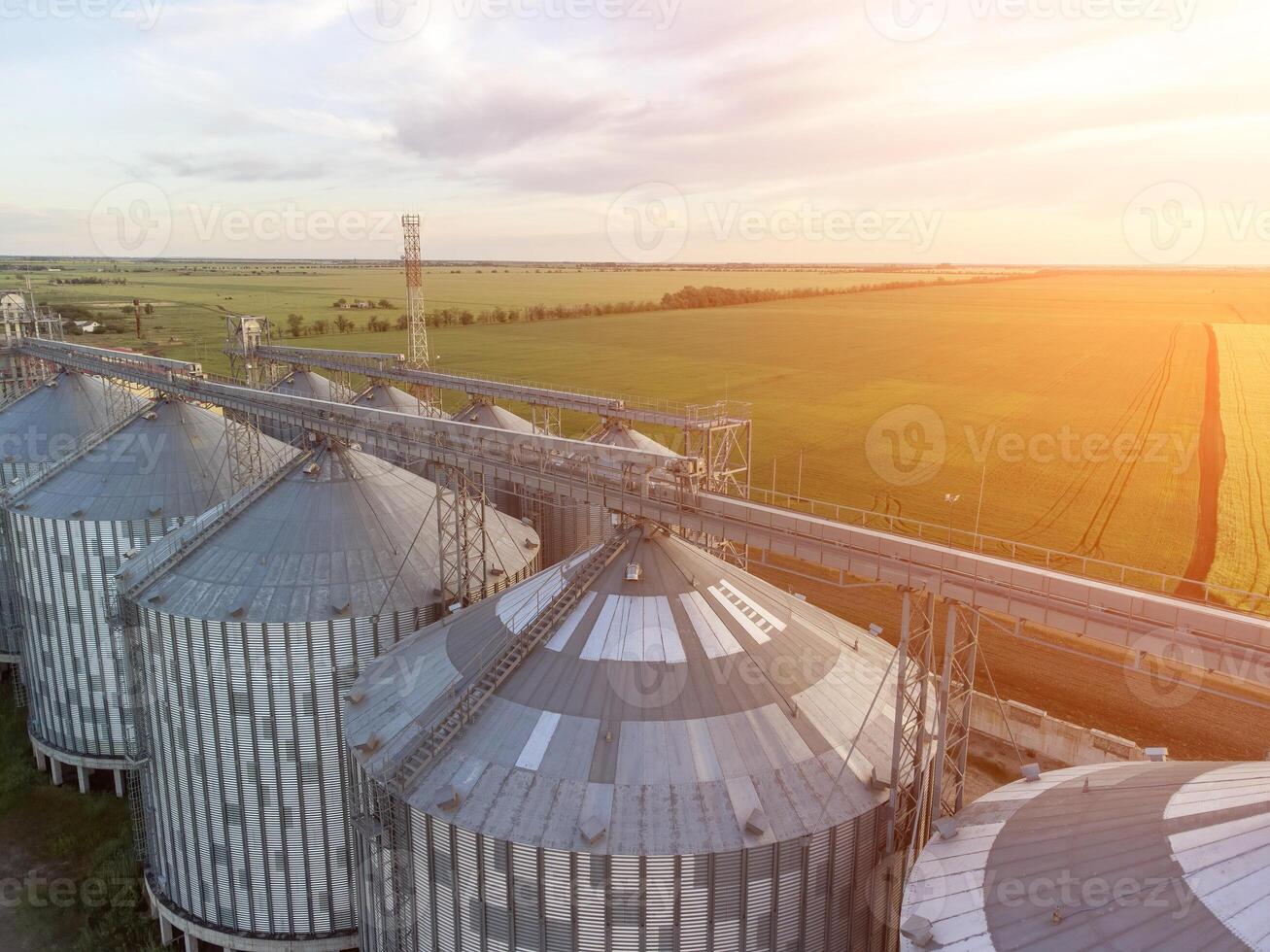 Modern metal silos on agro-processing and manufacturing plant. Aerial view of Granary elevator processing drying cleaning and storage of agricultural products, flour, cereals and grain. Nobody. photo
