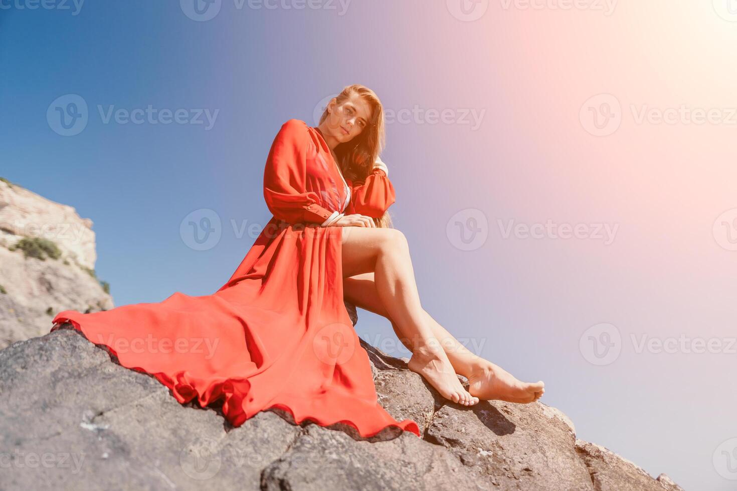 mujer viaje mar. joven contento mujer en un largo rojo vestir posando en un playa cerca el mar en antecedentes de volcánico rocas, me gusta en Islandia, compartiendo viaje aventuras viaje foto