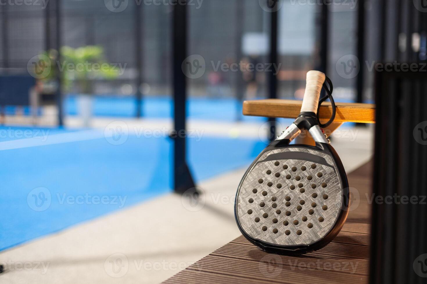 Paddle tennis. Paddel racket and ball in front of an outdoor court photo