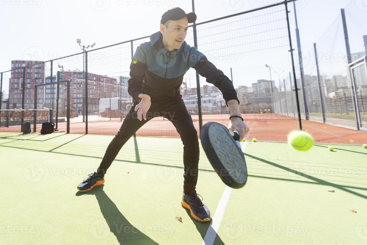 Man playing paddle tennis. Jumping and shooting the ball. photo