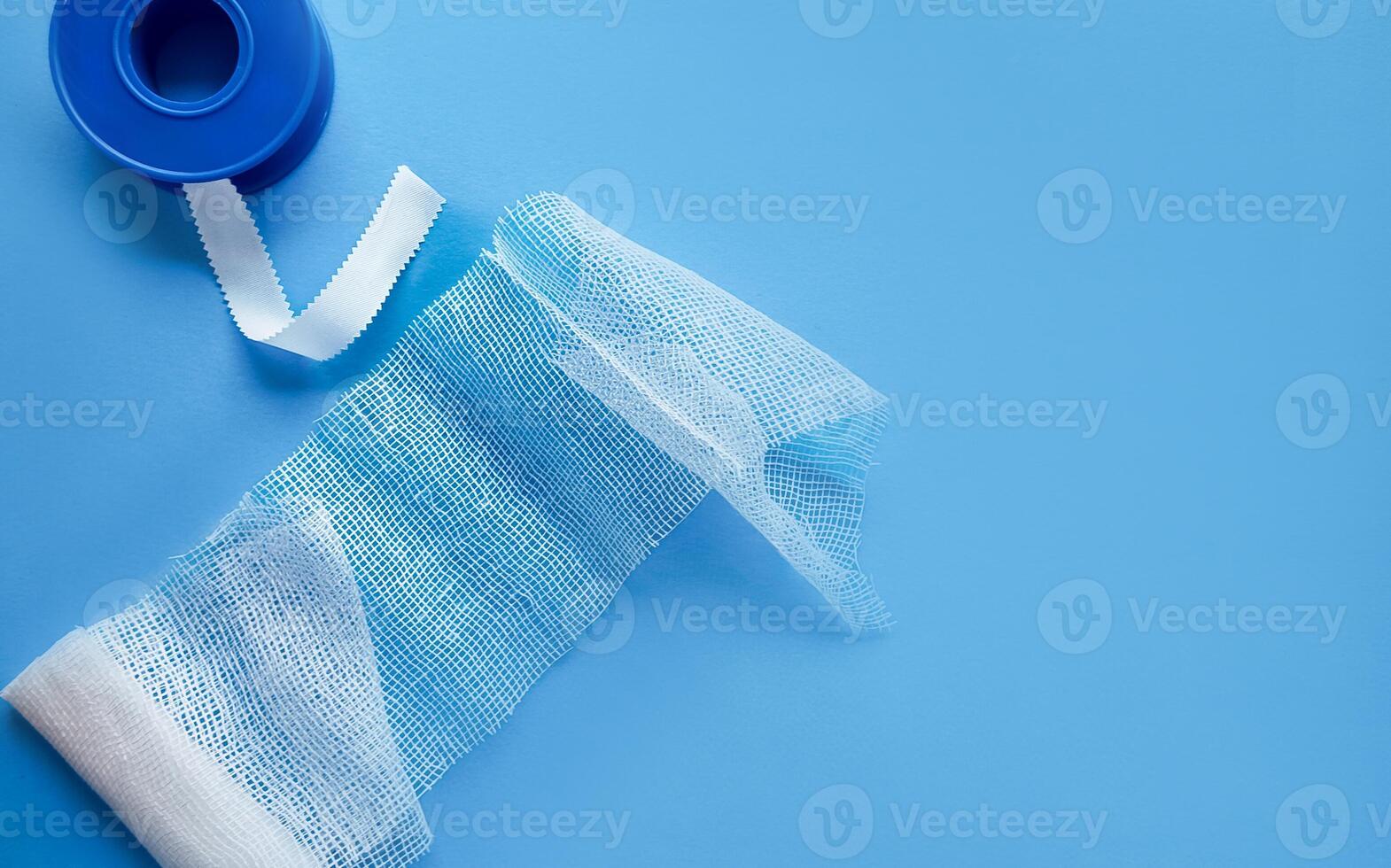 Unraveled Medical Bandage on Solid Blue Background photo