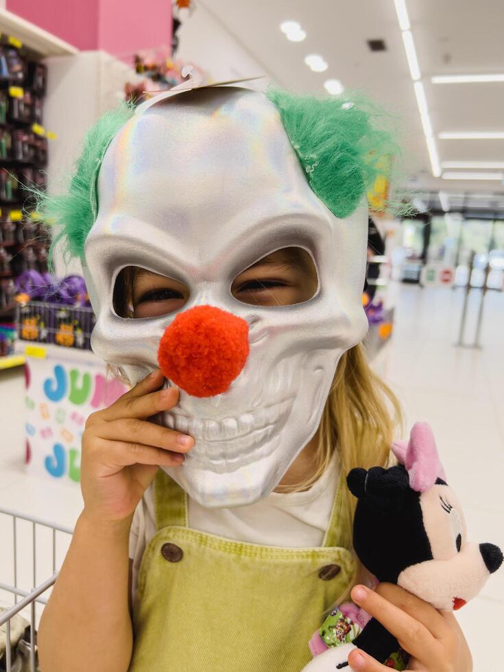podgorica, montenegro - 14 agosto 2023. pequeño niña en el Tienda molesto en un de miedo payaso máscara foto