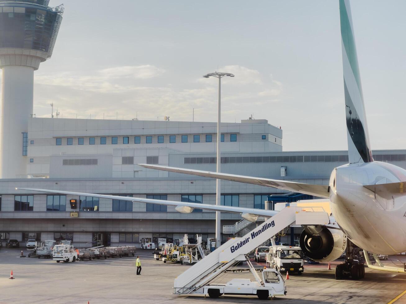 Afines, Greece - 20 august 2023. Airplane with a gangway stands in front of the airport building. Back view photo