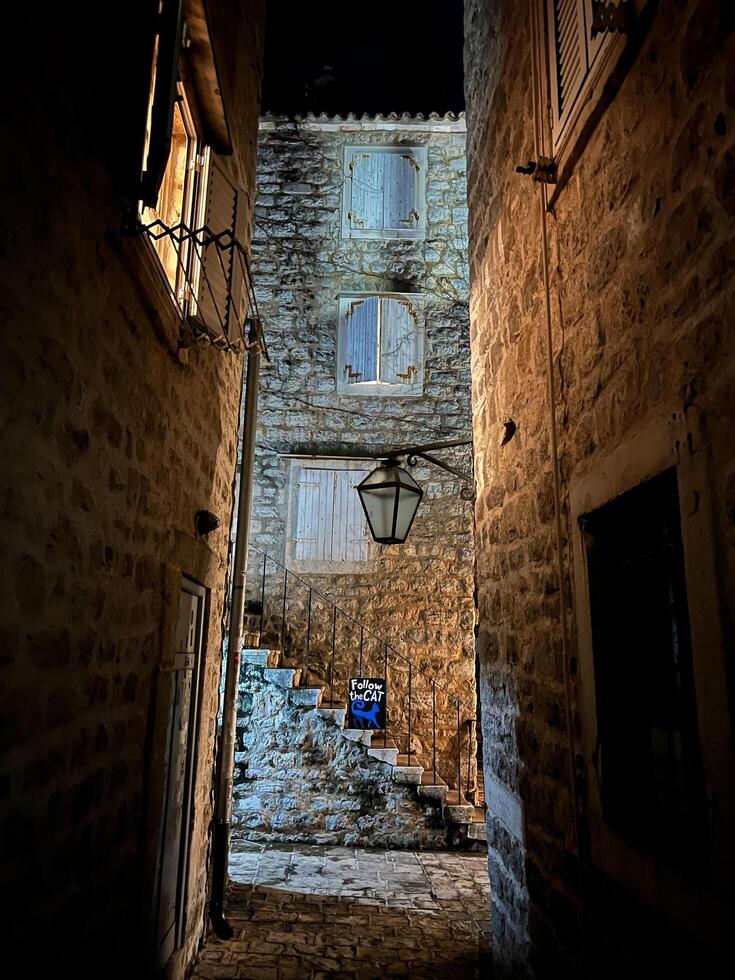 Budva, Montenegro - 25 december 2022. Narrow street between ancient stone buildings photo